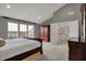 Comfortable main bedroom with a large bed, closet, dresser and scenic view from the windows at 9253 Windrift Way, Zionsville, IN 46077