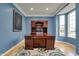 Stylish study with hardwood floors, a bay window, modern lighting, and a large stained wood desk at 9253 Windrift Way, Zionsville, IN 46077