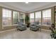 Bright sunroom featuring tile floors, neutral walls, two armchairs, and multiple windows at 9253 Windrift Way, Zionsville, IN 46077