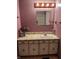 A charming bathroom with pink floral wallpaper, a vanity sink, a mirror, and a decorative vase at 930 N Ritter Ave, Indianapolis, IN 46219