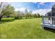 Expansive lawn bordered by mature trees and partial deck view provides privacy and room to roam at 10027 Landis Blvd, Fishers, IN 46040