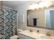 Well-lit bathroom with a double vanity, a large mirror, and a decorative shower curtain at 10027 Landis Blvd, Fishers, IN 46040