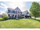 Beautiful two-story home with a manicured lawn, brick, and blue painted siding at 10027 Landis Blvd, Fishers, IN 46040