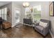 Cozy sitting area with a grey armchair, decorative accents, and natural light from the large windows at 10027 Landis Blvd, Fishers, IN 46040