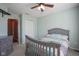 Neutral-toned bedroom with bed, dresser, large window with drapes, closet and ceiling fan at 10212 Ironway Dr, Indianapolis, IN 46239