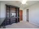 Bedroom with a large dark wood bookshelf, neutral carpet, ceiling fan, and walk-in closet at 10212 Ironway Dr, Indianapolis, IN 46239