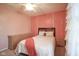 A charming bedroom with pink walls, a ceiling fan, and a white bed with a wooden headboard at 10212 Ironway Dr, Indianapolis, IN 46239