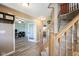 Hallway featuring vinyl floors, a staircase, and a view into the office and living room at 10212 Ironway Dr, Indianapolis, IN 46239
