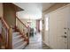 Inviting entryway featuring wood-look floors, a staircase, and a view into the dining area at 10212 Ironway Dr, Indianapolis, IN 46239