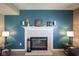 Close-up of the fireplace featuring a white mantel and teal accent wall at 10212 Ironway Dr, Indianapolis, IN 46239