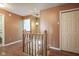 Upstairs hallway features hardwood floors, natural wood railing and access to bedrooms and bathrooms at 10212 Ironway Dr, Indianapolis, IN 46239