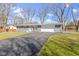 Inviting ranch-style home featuring a spacious driveway, attached garage, and attractive stone facade at 10427 N Delaware St, Carmel, IN 46280