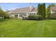 Spacious backyard with mature landscaping, a cozy deck, and a large, manicured lawn at 10725 Grindstone Dr, Fishers, IN 46037