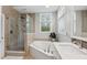Bathroom featuring a glass shower, soaking tub, and vanity with white countertop at 10725 Grindstone Dr, Fishers, IN 46037