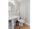 Bathroom featuring a pedestal sink, toilet, and a round mirror at 10725 Grindstone Dr, Fishers, IN 46037
