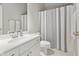 Bathroom with a white vanity, toilet, and shower/tub combo with a gray and white curtain at 10725 Grindstone Dr, Fishers, IN 46037