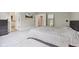 Bright bedroom with a gray bedspread, plush carpeting, and a view into the ensuite bathroom at 10725 Grindstone Dr, Fishers, IN 46037