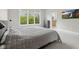 Bright bedroom with a large window, plush carpeting, and a view into the ensuite bathroom at 10725 Grindstone Dr, Fishers, IN 46037