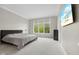 Modern primary bedroom with neutral colors, plush carpeting, a large window, and a mounted television at 10725 Grindstone Dr, Fishers, IN 46037