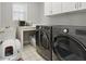 Well-organized laundry room with modern washer and dryer, sink, and ample storage space at 10725 Grindstone Dr, Fishers, IN 46037