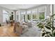 Sunlit living room with hardwood floors, comfortable seating, and large windows offering backyard views at 10725 Grindstone Dr, Fishers, IN 46037