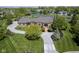 Expansive brick home with a circular driveway and lush landscaping bordering a pond at , Carmel, IN 46032