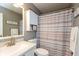 Bathroom features a sink vanity with a mirror and shower with a striped curtain and cabinet storage at 12929 Shandon Ln, Fishers, IN 46038