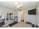Bedroom space is optimized with a treadmill, workout equipment, and TV for convenient exercise at 12929 Shandon Ln, Fishers, IN 46038