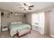 A cozy bedroom features a ceiling fan, neutral walls, and a decorative shelf with pictures at 12929 Shandon Ln, Fishers, IN 46038