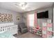 Bedroom showcasing a crib, glider chair, and cheerful decor perfect for a new baby at 12929 Shandon Ln, Fishers, IN 46038