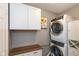 Laundry room featuring stackable washer and dryer, white cabinets, and a wooden folding table at 12929 Shandon Ln, Fishers, IN 46038