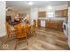 Well-lit dining area with a wooden table set beside the kitchen with wood cabinets and wood laminate floor at 14014 Keams Dr, Fishers, IN 46038