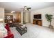 Open-concept living room featuring a fan, carpet flooring, and an open layout to the kitchen area at 14014 Keams Dr, Fishers, IN 46038