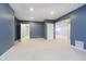 Finished basement with blue accent wall, featuring neutral carpet and multiple doorways at 14339 Jeremy Dr, Carmel, IN 46033