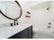 Bathroom with a navy vanity, marble countertop, and a round mirror over the sink at 14339 Jeremy Dr, Carmel, IN 46033