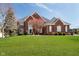 Stunning two-story brick home with a well-manicured lawn and mature landscaping at 14339 Jeremy Dr, Carmel, IN 46033