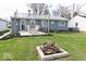 Large grassy backyard with a patio, string lights, and firepit at 1508 N Woodridge Ave, Muncie, IN 47304
