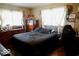 Cozy bedroom with hardwood floors, dresser, and natural light at 1508 N Woodridge Ave, Muncie, IN 47304