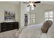 Bright bedroom featuring a ceiling fan, closet, dark dresser and artwork of the city skyline at 2037 Rhettsbury St, Carmel, IN 46032