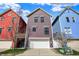 Exterior view of colorful townhomes featuring a two-car garage and landscaped front yards at 2037 Rhettsbury St, Carmel, IN 46032