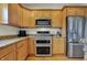 Gourmet kitchen with stainless steel double oven, microwave, and refrigerator at 2037 Rhettsbury St, Carmel, IN 46032