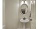 Elegant powder room with pedestal sink, decorative mirror, and modern lighting at 2037 Rhettsbury St, Carmel, IN 46032