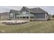 Backyard of a home featuring concrete patio, manicured grass, blue siding, brick trim, and architectural roof design at 2145 W Bedrock Ln, Greenfield, IN 46140