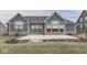 Backyard view showing concrete patio, blue siding, and brick trim, with surrounding well-manicured yard at 2145 W Bedrock Ln, Greenfield, IN 46140