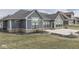 Wide shot of the backyard featuring concrete patio, blue siding, brick trim, dark roofing, and well-manicured lawn at 2145 W Bedrock Ln, Greenfield, IN 46140