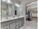 Bathroom with double sinks, gray cabinetry, white countertop, and a walk-in closet with organizational shelves at 2145 W Bedrock Ln, Greenfield, IN 46140