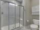 Modern bathroom featuring tile surround glass shower, neutral walls, gray flooring, and white cabinetry at 2145 W Bedrock Ln, Greenfield, IN 46140