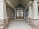 Inviting entryway featuring a beautiful wooden double-door, brick accents, and covered porch at 2145 W Bedrock Ln, Greenfield, IN 46140