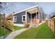 Charming home featuring a new facade, a welcoming porch with a red door, complemented by a fresh lawn at 242 N Tacoma Ave, Indianapolis, IN 46201