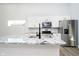 Modern kitchen with white cabinets, stainless steel appliances, and light granite countertops at 242 N Tacoma Ave, Indianapolis, IN 46201